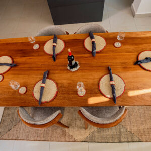 Dining table styled with handcrafted placemats, coasters, napkin rings, and woven centerpiece by Irebe Basket Collection.