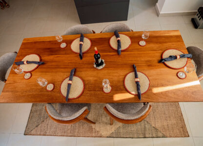 Dining table styled with handcrafted placemats, coasters, napkin rings, and woven centerpiece by Irebe Basket Collection.