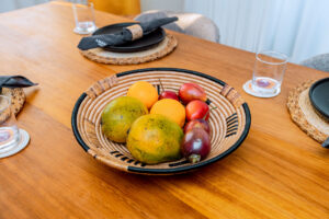Handwoven bowl centerpiece holding fresh fruits, handcrafted by Irebe Basket Collection for an intentional luxury dining table